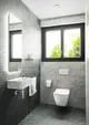 Ideal Standard Waschtisch mit integriertem Wasserhahn in modernem Design, montiert an der Wand, neben einem Wand-WC und Fenster mit Blick ins Freie.